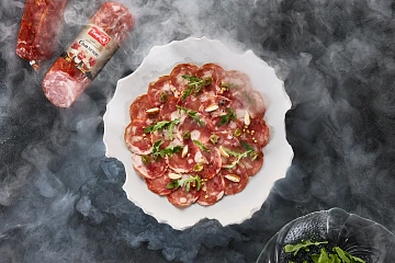 Закуска с сырокопчёным «Сальчичоном» с ореховым соусом и рукколой